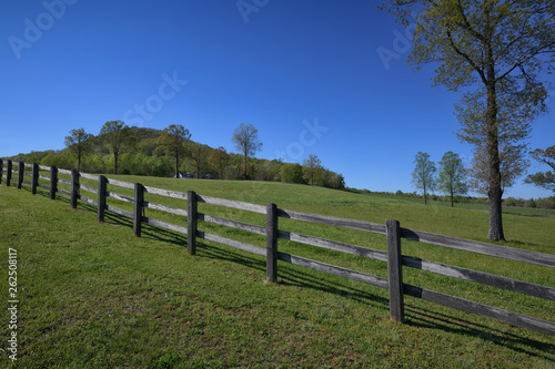  The Fence and the Hill  a wood fence and green pasture in springtime with Blue Ridge Mountains in the Background ZDS Americana Fences Collection
