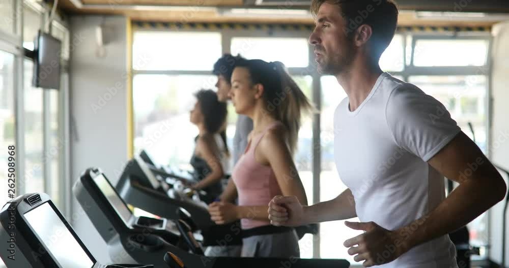Young people running on a treadmill in gym