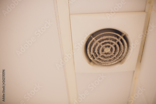 Wall electric extractor fan for bathroom. Closeup dirty, dust, unsanitary conditions.