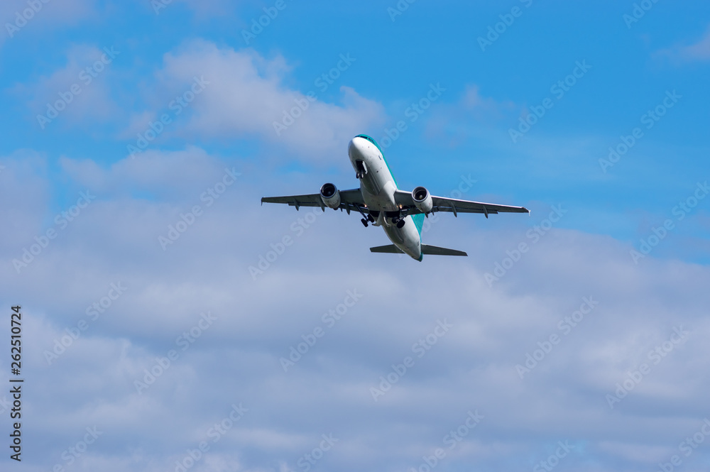 Airplane in flight viewed from the ground, with clouds Airplane in flight viewed from the ground, with clouds