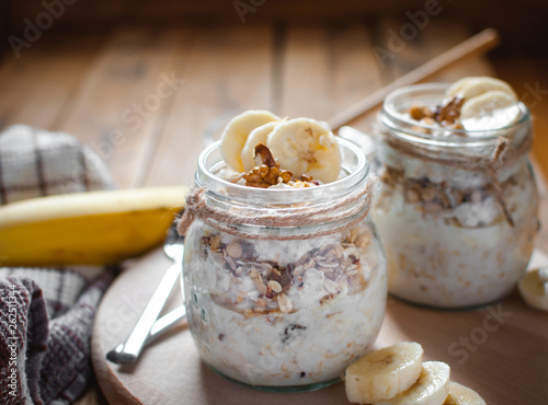 Close-up of homemade banana oats in a glass jar on wooden background