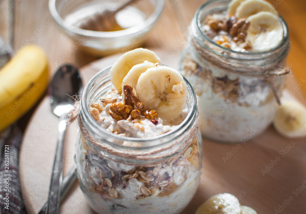 Close-up of homemade banana oats in a glass jar on wooden background Close-up of homemade banana oats in a glass jar on wooden background