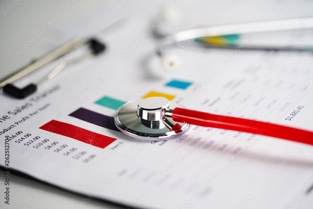 Stethoscope and US dollar banknotes on chart or graph paper, Financial, account, statistics and business data medical health concept. Stethoscope and US dollar banknotes on chart or graph paper, Financial, account, statistics and business data medical health concept.