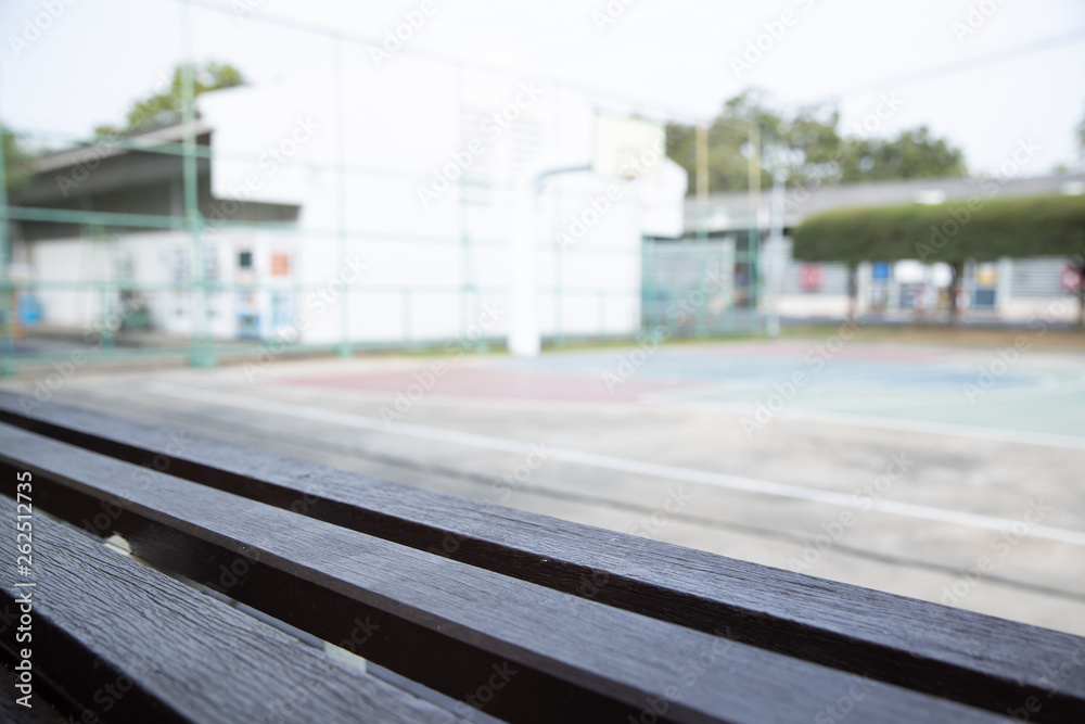 Fototapeta premium empty old wooden bleachers with blurred basketball court background.