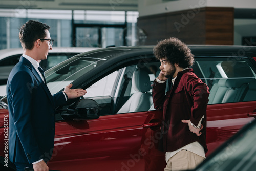 car dealer showing red automobile to curly man © LIGHTFIELD STUDIOS