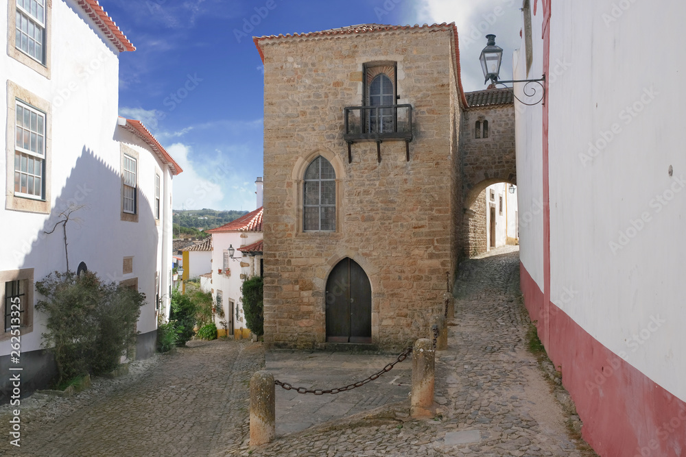 Narrow streets and arches of the medieval city of Obidos in Portugal with old stone houses and cobbled streets