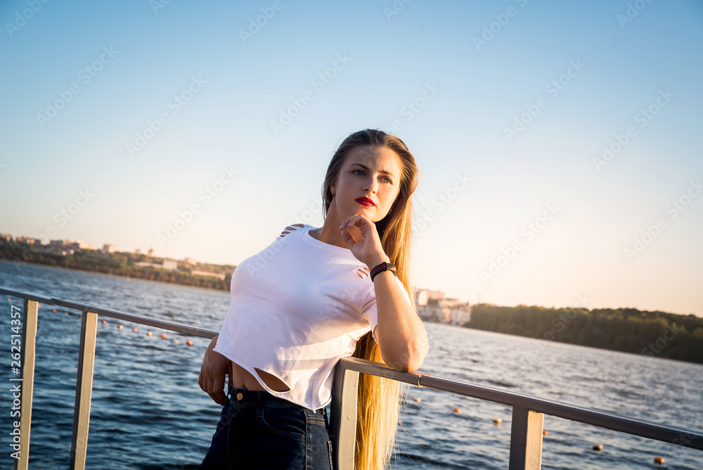 Young beautiful woman walking in park with lake