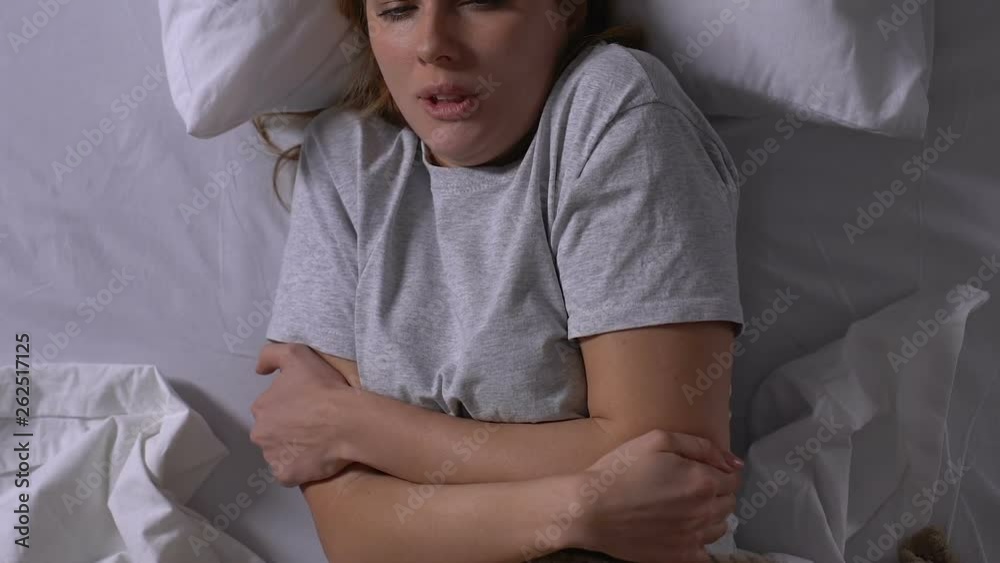 Sick woman with fever lying in bed, suffering from flu symptoms, epidemic