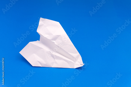 Flat lay of white paper plane and blank paper on pastel blue color background.Horizontal .