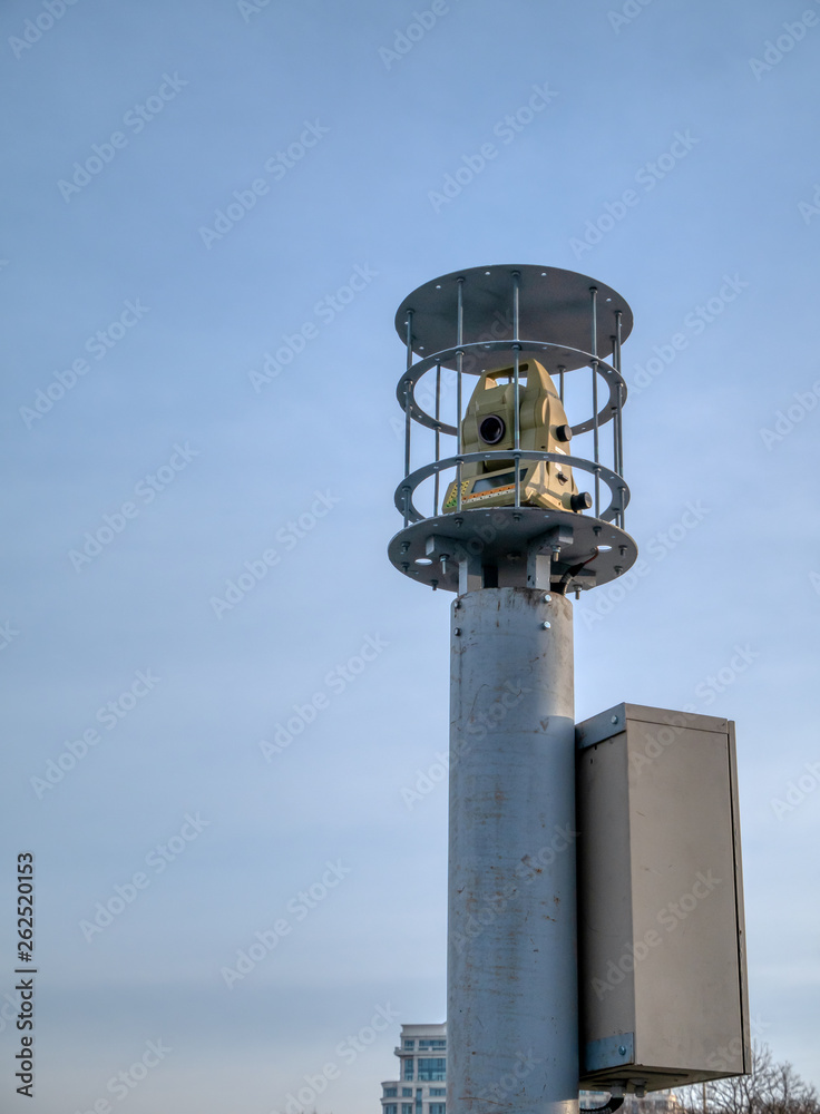 modern theodolite geodesy equipment in security cage on tall column modern theodolite geodesy equipment in security cage on tall column