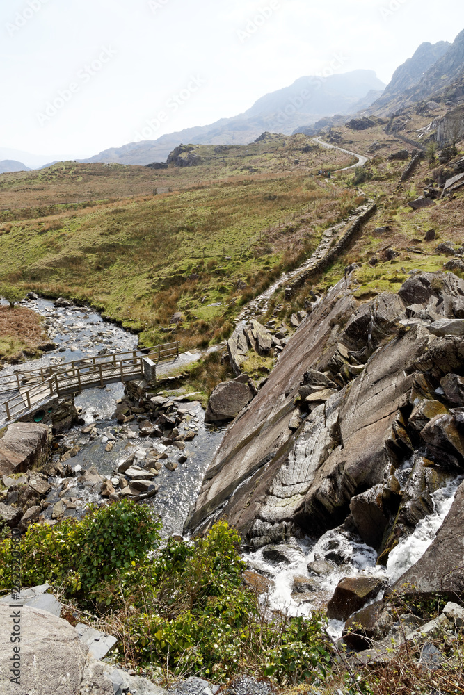 Wooden bridge on the Cwmorthin Waterfall trail in the mountains of Snowdonia National Park, Wales. Wooden bridge on the Cwmorthin Waterfall trail in the mountains of Snowdonia National Park, Wales.