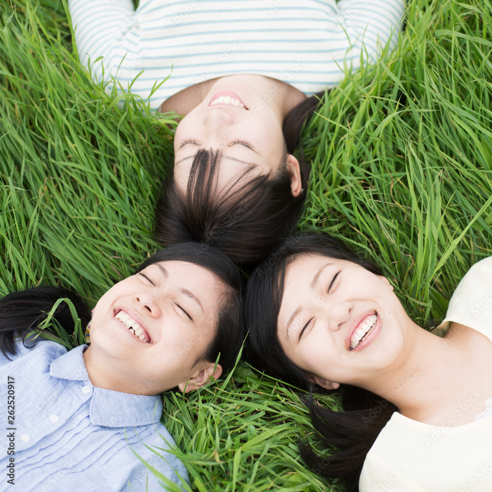 草原に寝転ぶ3人の女性 Stock Photo Adobe Stock
