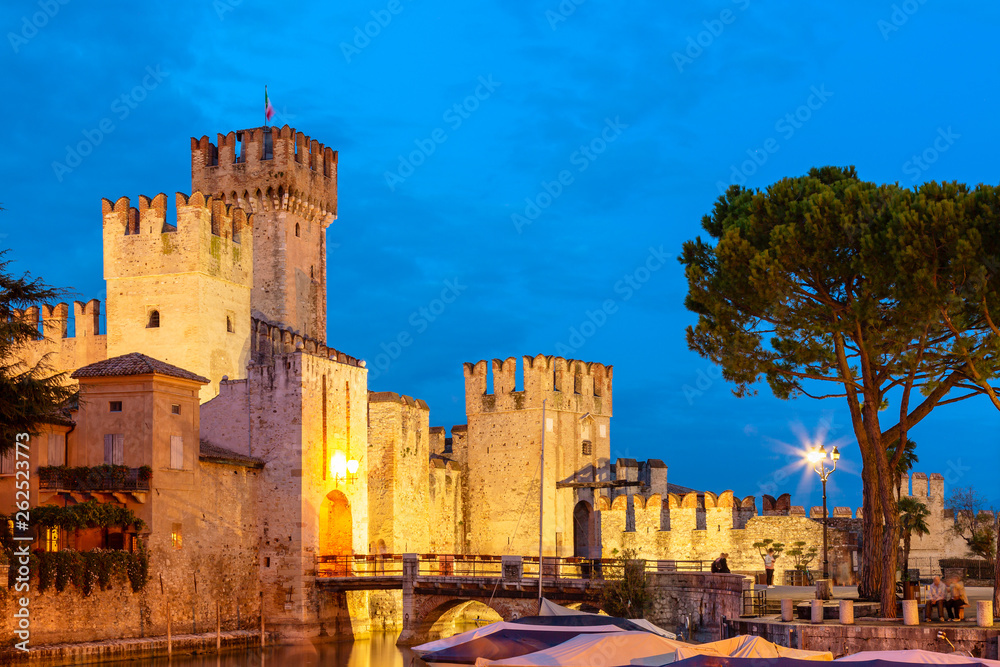 Scaligero Castle during evening sunset, medieval fortress in the town of Sirmione, surrounded by the Lake Garda. Sirmione, Italy