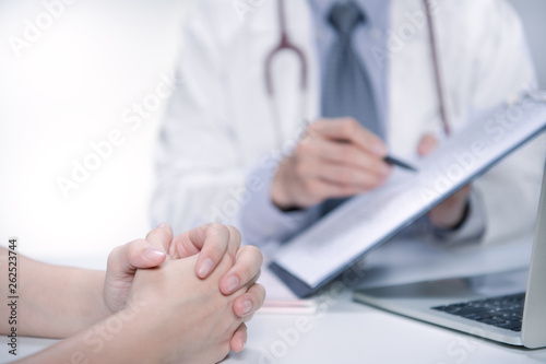 Medical doctor and patient discussing and consulting in hospital examination room