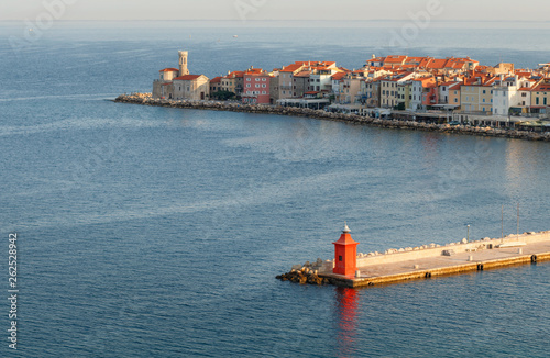 Obraz na płótnie Skyline of Piran port and colorful houses during sunrise with old red lighthouse, Slovenia w salonie