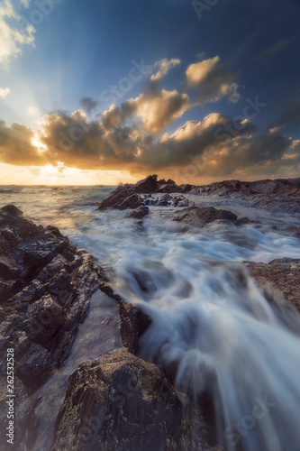 Nature landscape, seascape, motion blurred of beach wave hitting rocks with dramatic clouds sunrise or sunset scenery at Pantai Tanjung Jara, Dungun.