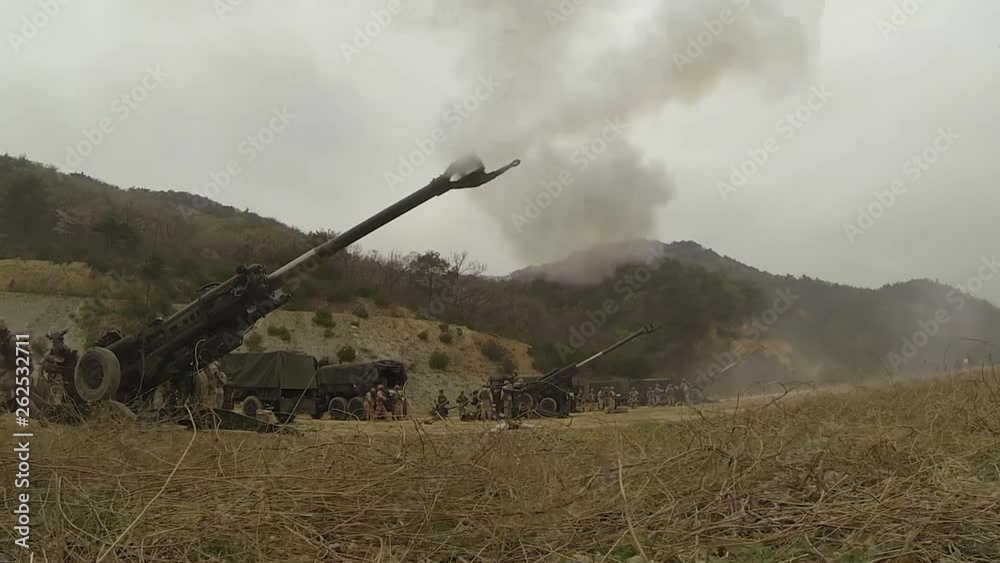 Soldiers firing M777 howitzers in an open field 2