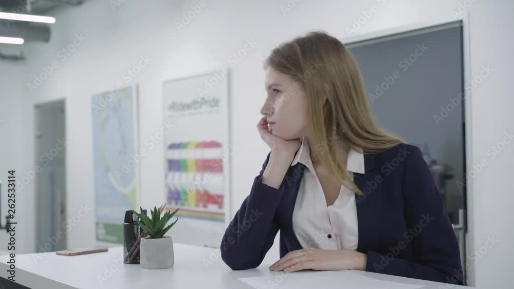 Concerned thoughtful young lady in formal clothes attentively checking papers in the office standing at the counter. Woman with long hair is upset, she is trying to solve problem. Camera moves right Concerned thoughtful young lady in formal clothes attentively checking papers in the office standing at the counter. Woman with long hair is upset, she is trying to solve problem. Camera moves right