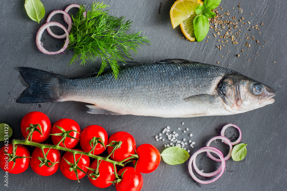 Raw seabass fish with ingredients for cooking a hot dish, top view Raw seabass fish with ingredients for cooking a hot dish, top view