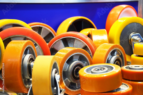 Group of different size and diameter industrial small wheels in warm yellow and orange colors for sale. Heavy Duty Fixed Polyurethane Industrial trolley Swivel Rubber Caster Wheels. photo