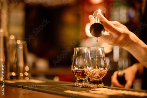 Obraz na plátně Bartender pouring whisky in a glass