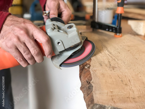 closeup hands of a carpenter working with emery wheel
