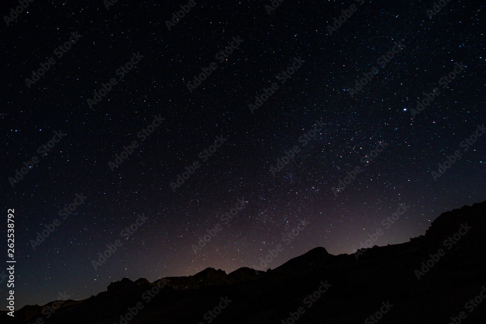 night photos on the Teide volcano in Tenerife. Images of the starry sky at night with the glow of the cities on the horizon