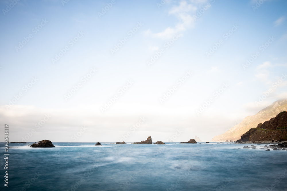 Sea view, marine panorama of the coast at sunset, sea, mountains, rocks, clouds and waves with soft light. Tenerife island coast and sea at sunset Sea view, marine panorama of the coast at sunset, sea, mountains, rocks, clouds and waves with soft light. Tenerife island coast and sea at sunset