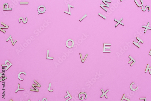 Wooden ABC alphabet letters on pink background.Love word written with wooden letters