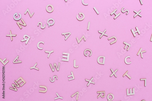 Wooden ABC alphabet letters on pink background