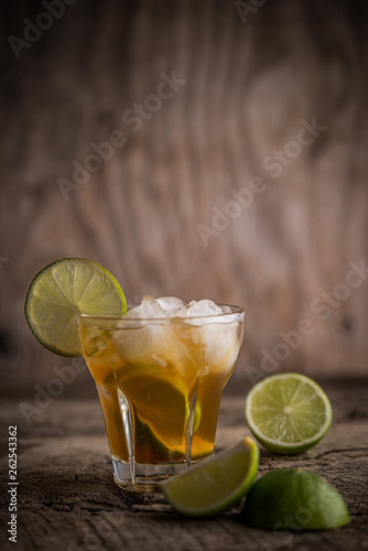 Caipirinha coctail with lemon slices and mint on rustic background