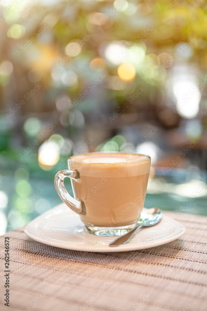 Hot coffee late over blurred garden with vintage warm light