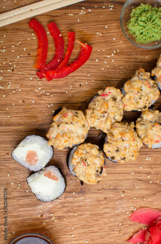 Unusual sushi rolls on a wooden table. Ukrainian sushi rolls with baked cheese and crabs