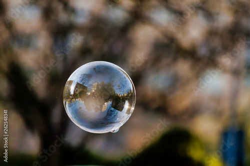 Lonely Colorful Soap Bubble with Reflection of the City and Sky Inside It