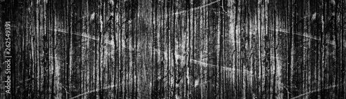 Wide black grunge background. Old weathered dark concrete wall panoramic texture. Dirty stains and scratches