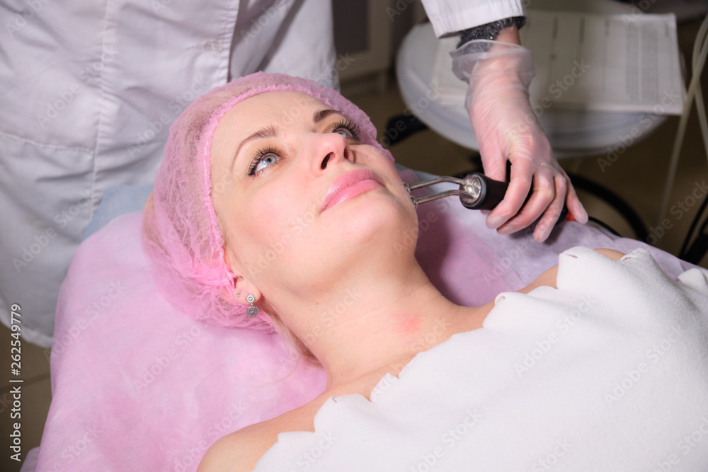 Cosmetologist making hardware procedures for the face to her patient . Anti-ageing and smoothing procedure in a beauty salon. Doctor in a cosmetological clinic making a treatment of skin care Cosmetologist making hardware procedures for the face to her patient . Anti-ageing and smoothing procedure in a beauty salon. Doctor in a cosmetological clinic making a treatment of skin care
