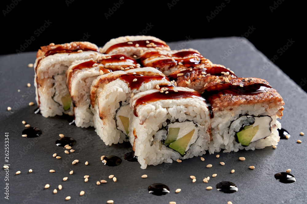 Uramaki rolls served on stone slate plate. Uramaki rolls served on stone slate plate.