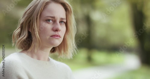 Lonely sad woman crying alone with a road into the far behind her