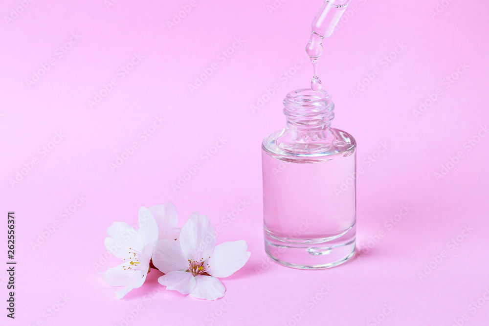 Serum and dropper on a pink background close-up Serum and dropper on a pink background close-up