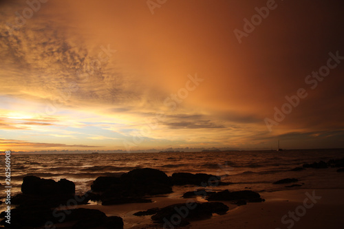 Sunset after heavy rain with arcus shelf storm clouds and stones in the ocean on tropical island Ko Lanta, Thailand