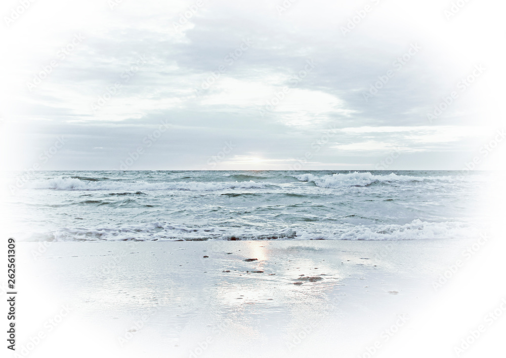 Fototapeta premium Light turquoise photo of the sea and sky with vignette. Background for tourism postcards and print design with waves by the shore and the beach. Sunset in the ocean.