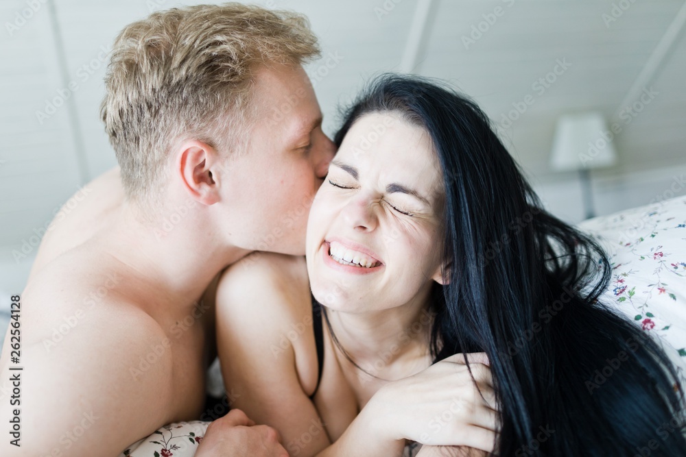 Handsome man kissing and nice woman in bed Handsome man kissing and nice woman in bed