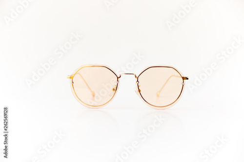 Isolated image of pink sunglasses with pink frame and gold color earpiece. Front view.