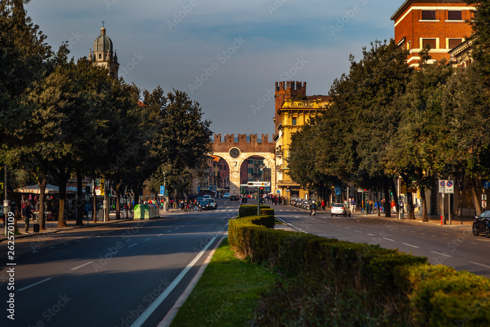 Fototapeta premium Verona, Italy – March 2019. Streets and buildings of ancient Verona city at the sunny summer day. Funny car by restourant
