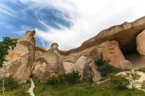 Hoodoos of Cappadocia. Big rocks carved by wind and water through time. Clouds and grass. Open Air Museum of Cappadocia, Nevsehir / Turkey