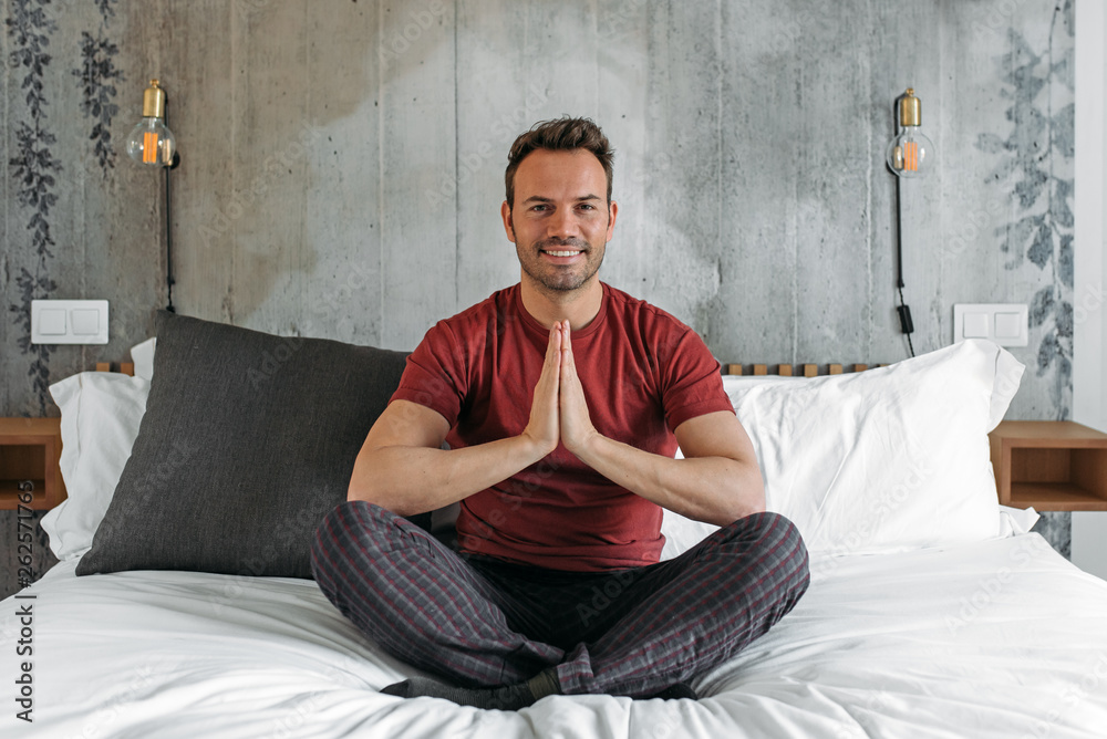 Fototapeta premium Attractive man on bed meditating