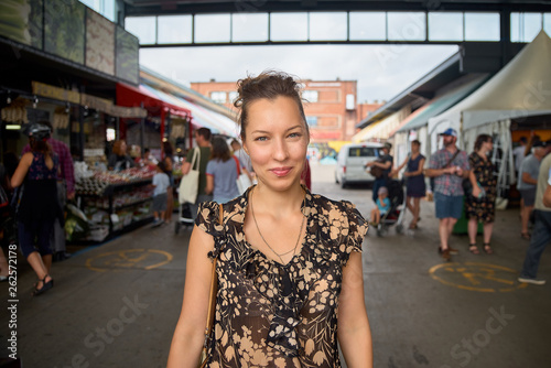 Portrait of a smiling woman at the Jean-Talon farmers market. The joyful visitors of the market are smiling at the camera.