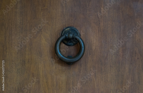 Black door knocker on a wooden door