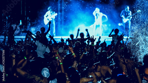 silhouettes of concert crowd in front of bright stage lights, pool party © pixfly