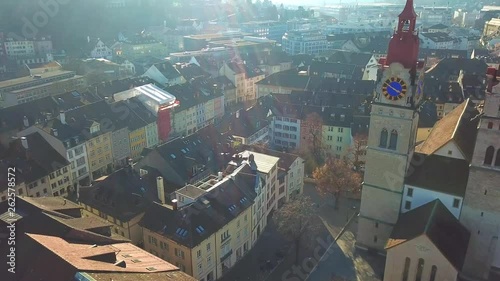 Drone flight with aerial view above church in old town of Winterthur in Switzerland. Tower and building roofs from above. Dynamic, stabilized and smooth shots of European town. photo